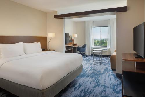 リンカーンにあるFairfield Inn & Suites by Marriott Lincoln Southeastの大きなベッドと机があるホテルの部屋