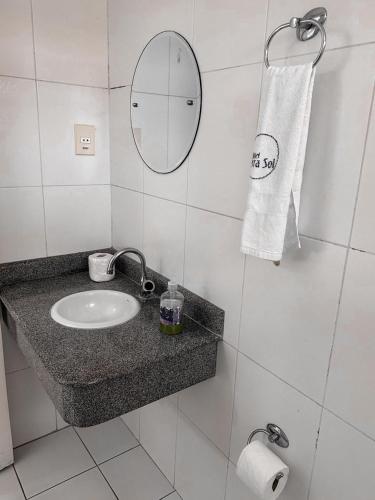 a white bathroom with a sink and a mirror at Hotel Serra Sol in Serrinha