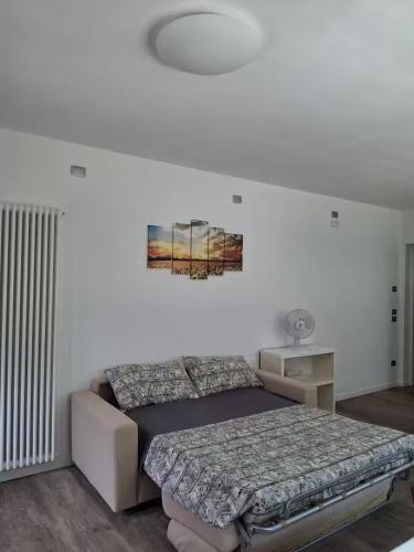 a bedroom with a bed and a painting on the wall at Terra di Mezzo in Valbrenta 