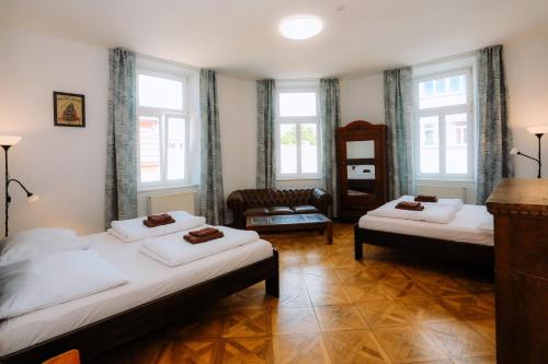 a room with two beds and a chair and windows at Cuba Bar & Hostel in České Budějovice