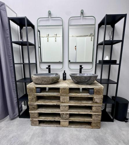 a bathroom with two sinks in front of two mirrors at MüdeMöwe in Hamburg