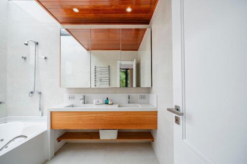 a bathroom with a sink and a mirror at Casa Atalaia 550m Praia c/ Hidro by Achei Camboriú in Praia Brava
