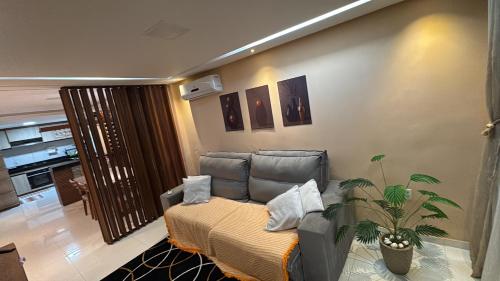 a living room with a couch and a plant at Casa centro in Porto Seguro