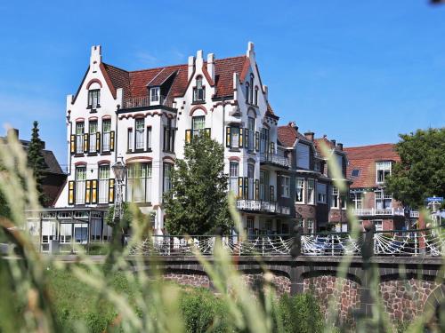 a large building on the side of a river at Hotel Molendal in Arnhem