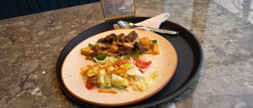 a plate of food with meat and vegetables on a table at MoonBasa Boutique Hotel and Spa Infopark , Kakkanad in Cochin