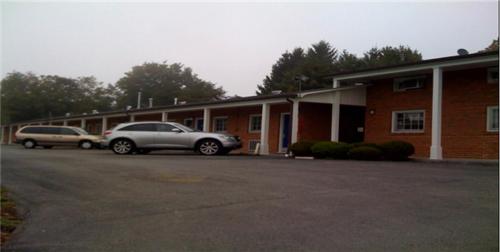 dos autos estacionados en un estacionamiento frente a un edificio en Relax Inn Lewisburg, en Lewisburg
