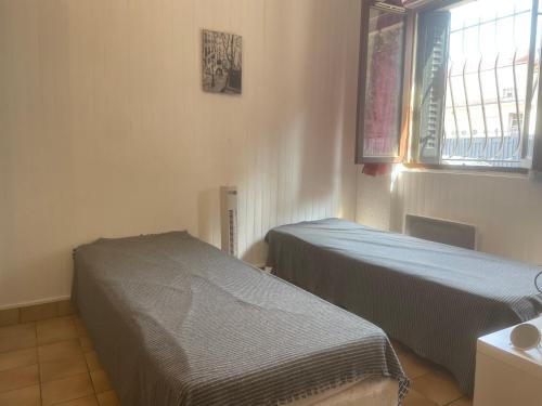 ein Zimmer mit zwei Betten und einem Fenster in der Unterkunft Studio 20m2 Ground Floor street in Colombes