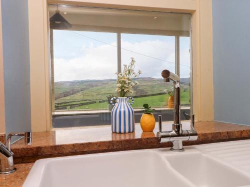 d'un évier de cuisine avec une fenêtre offrant une vue. dans l'établissement Stone & Fleece Cottage, à Holmebridge