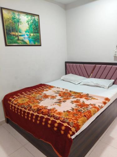 a bedroom with a bed with a blanket on it at Hotel Dream in Rajkot