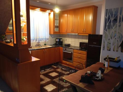 a kitchen with wooden cabinets and a table and a tableablish at DREAM Home Ioannina in Ioannina