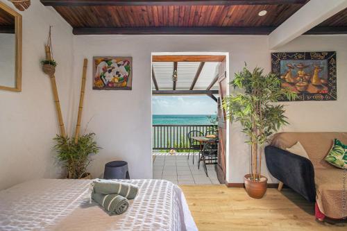 a bedroom with a bed and a view of the ocean at Appartement Alizé Vue Imprenable Sur La mer in Sainte-Luce
