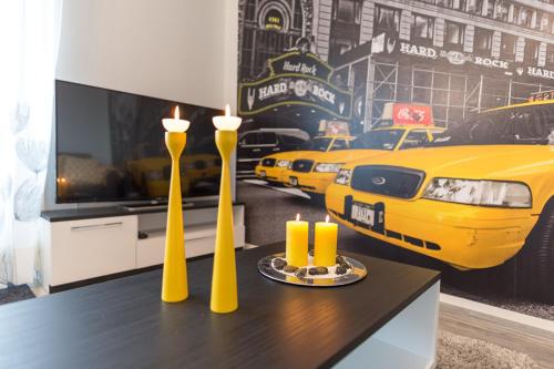 a dining table with two yellow candles and a yellow taxi mural at Safaritalo Apartments in Kalajoki