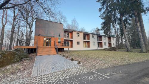 a house with a staircase in front of it at Apartamenty Dabrowka Plus - w lesie, prywatny parking, park, sauna, miejsce grillowe in Jelenia Góra