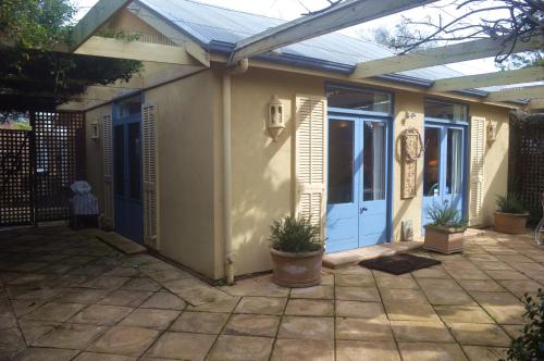 a house with a blue door and a patio at Athelney Cottage Bed and Breakfast in Adelaide