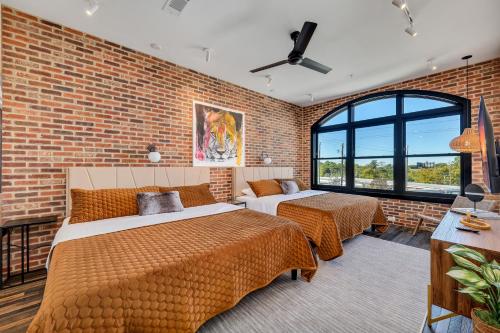 アトランタにあるTop Floor Penthouse Loftsのレンガの壁、ベッド2台が備わるベッドルーム1室が備わります。