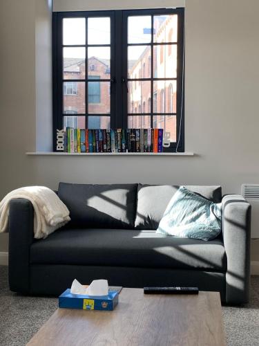 a black couch in a living room with a window at Stylish apartment in Halifax in Halifax