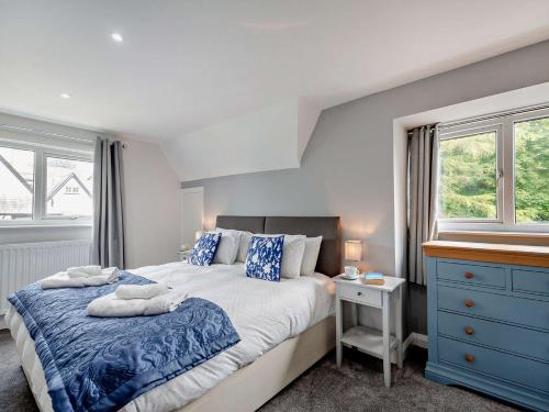 ein Schlafzimmer mit einem großen Bett und einer blauen Kommode in der Unterkunft 4 Bed in Beaumaris 94501 in Llanddona