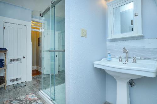 a white bathroom with a sink and a shower at The Caddis Cottage in Salida