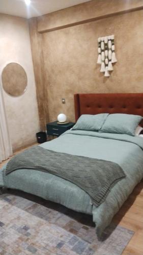 a bedroom with a large bed with a wooden headboard at Loft Dolce Vita in Santeagueda