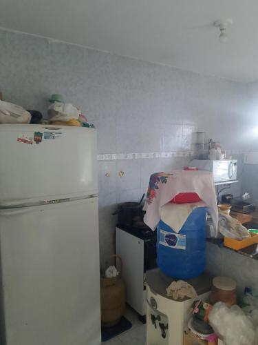 eine kleine Küche mit einem weißen Kühlschrank und einer Theke in der Unterkunft Hostel da Josi - Porto de Galinhas in Porto De Galinhas
