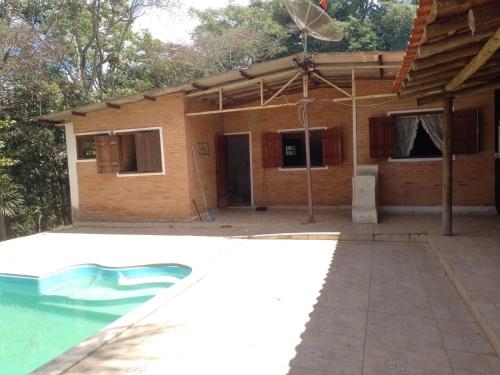 a house with a swimming pool in front of it at Sitio Recanto das águas in São João del Rei