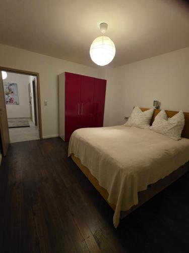 a bedroom with a large bed with a red cabinet at Bello in Wallerfangen