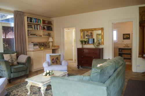 a living room with two chairs and a couch at Athelney Cottage Bed and Breakfast in Adelaide