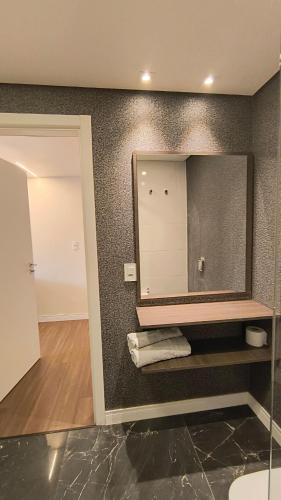 a bathroom with a large mirror on the wall at Saint Sebastian in Jaraguá do Sul