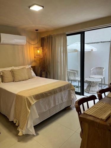 a bedroom with a large bed and a balcony at Aurea Bauten in João Pessoa