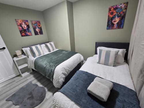 a small bedroom with two beds and paintings on the wall at Room 2 Shared house 5 min from Sefton Park in Liverpool