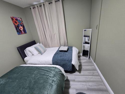 a small bedroom with two beds and a mirror at Room 2 Shared house 5 min from Sefton Park in Liverpool