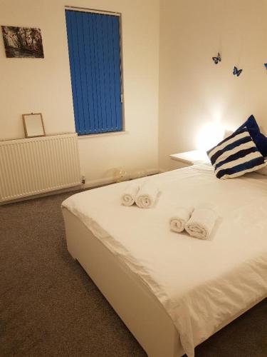 a bedroom with a large white bed with towels on it at Small Bedroom for 3 People, Friendly Cats in Common Areas in London