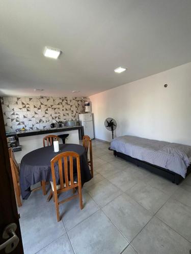 a bedroom with a bed and a table and chairs at Complejo de departamentos H&H in Guaymallen