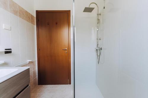 a shower with a wooden door in a bathroom at Prosecco paradise place in Campea