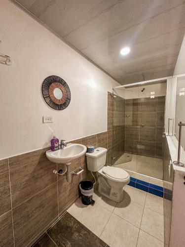 a bathroom with a toilet and a sink and a shower at Eco Hostal La Perla Tayrona in El Zaino