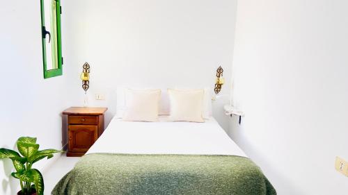 een slaapkamer met een wit bed en een groene deken bij Terraza del Mar in Arrieta