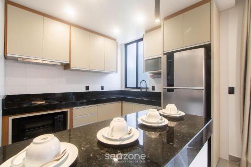 eine Küche mit schwarzen Arbeitsplatten und weißen Geräten in der Unterkunft Estadia completa com piscina e a 350m da Praia PRY in Porto Seguro