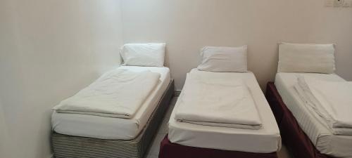 two twin beds in a small room with at نزل الاوئل in Al Madinah