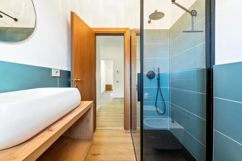 a bathroom with a glass shower and a sink at Lakefront apartment with terrace near Como in Montorfano