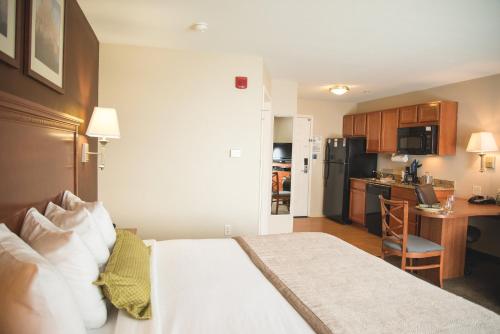a hotel room with a bed and a kitchen at Candlewood Suites Loveland by IHG in Loveland