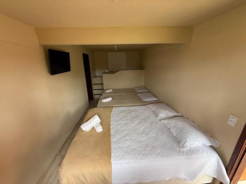 a small room with a bed with towels on it at Suíte4 Pousada Arpoador a pé da Praia Búzios in Búzios