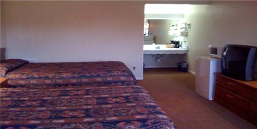 ein Hotelzimmer mit einem Bett und einem TV in der Unterkunft Relax Inn Lewisburg in Lewisburg