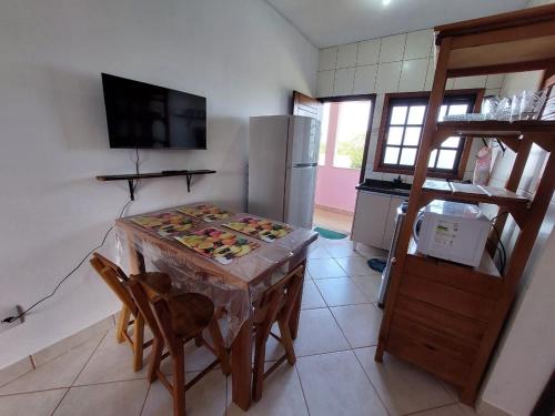 a kitchen with a table and chairs and a refrigerator at Flat Beira Mar in Ilha Comprida