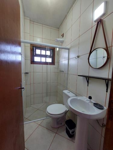 a bathroom with a toilet and a sink at Flat Beira Mar Bermudas in Ilha Comprida