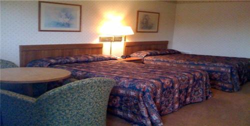 a hotel room with two beds and a table and chairs at Relax Inn Lewisburg in Lewisburg