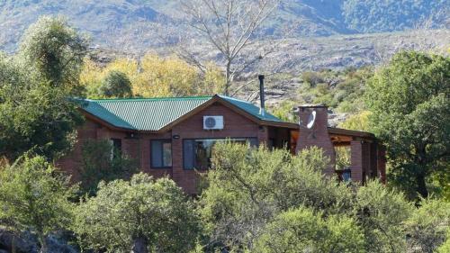 a brick house in the middle of a forest at Cabañas Pampa in Mina Clavero