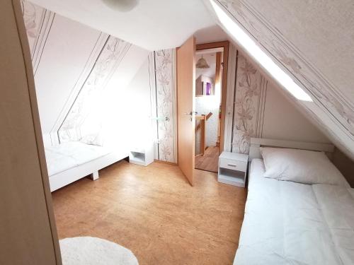 a small attic room with a bed and a window at Piratennest in Osteel