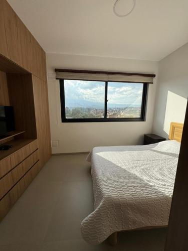 ein Schlafzimmer mit einem Bett und einem großen Fenster in der Unterkunft Mono Ambiente 10A in Tarija