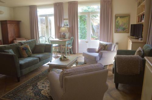 a living room with couches and chairs and a table at Athelney Cottage Bed and Breakfast in Adelaide