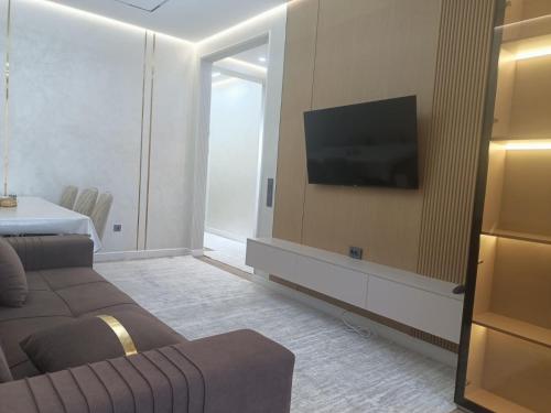 a living room with a couch and a flat screen tv at Уютная двух комнатная квартира возле Simketsity mall in Shymkent